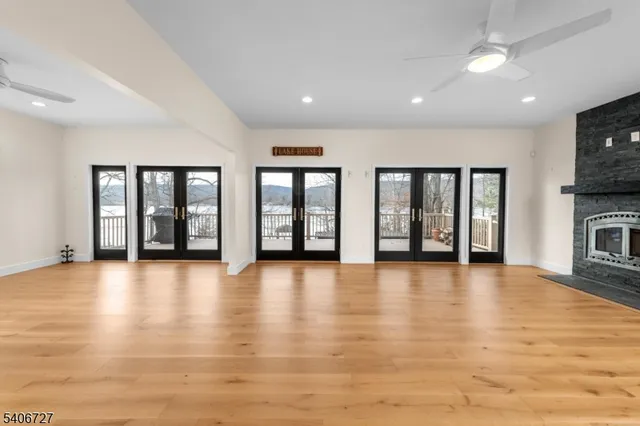 an empty room with wooden floor and floor to ceiling window