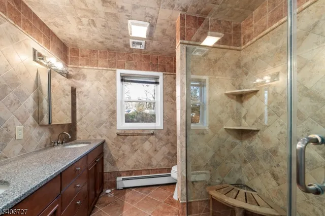 a bathroom with a granite countertop sink toilet and shower