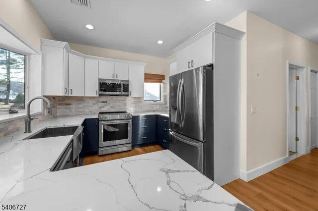 a kitchen with granite countertop a refrigerator and a sink