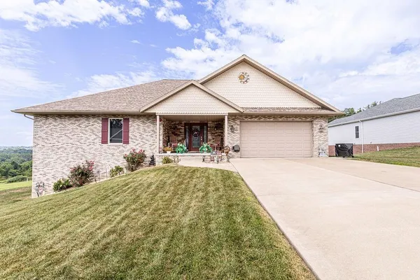 a front view of a house with yard outdoor seating and garage