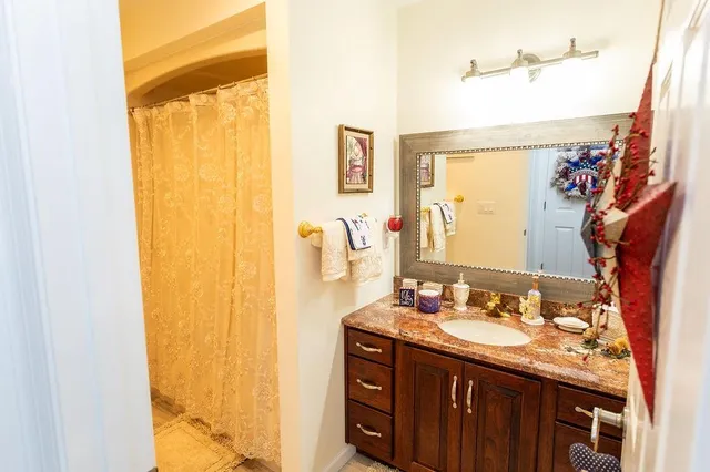 a bathroom with a granite countertop sink and a mirror