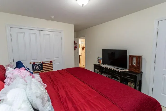 a bedroom with a bed and a flat screen tv