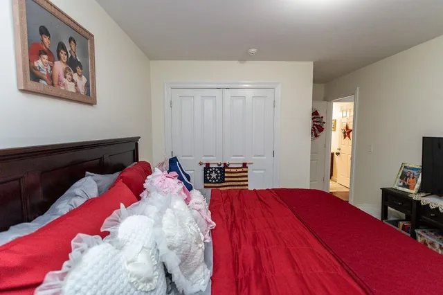 a bedroom with a large bed and a chandelier