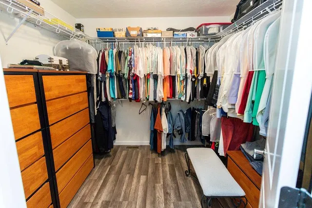 a view of walk in closet with clothes and shoes