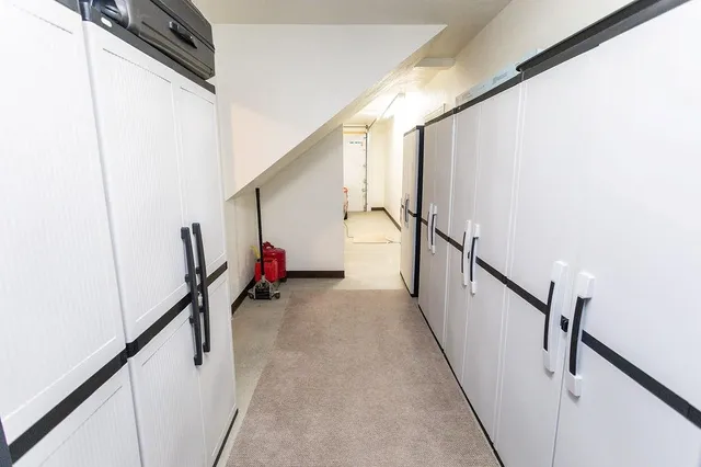 a view of a hallway with wooden floor and stairs