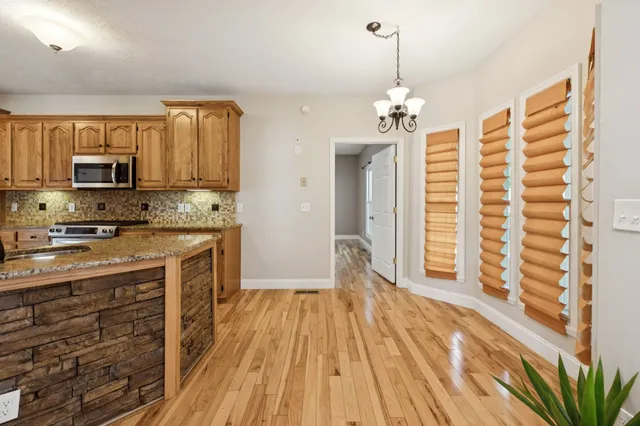 a view of empty room with wooden floor and entryway