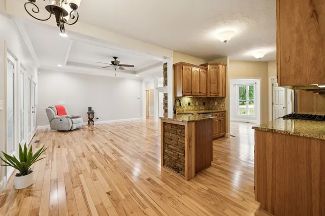 a large kitchen with stainless steel appliances granite countertop a lot of counter space and wooden floors