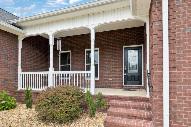 a front view of a house with a garden and yard