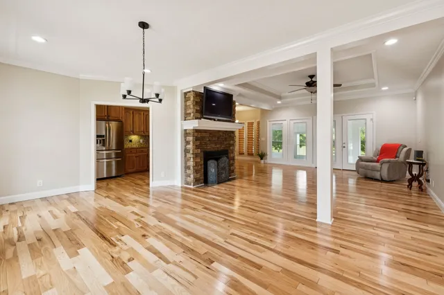 a view of a livingroom with furniture an empty room and wooden floor
