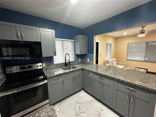 a kitchen with stainless steel appliances granite countertop a sink and a stove