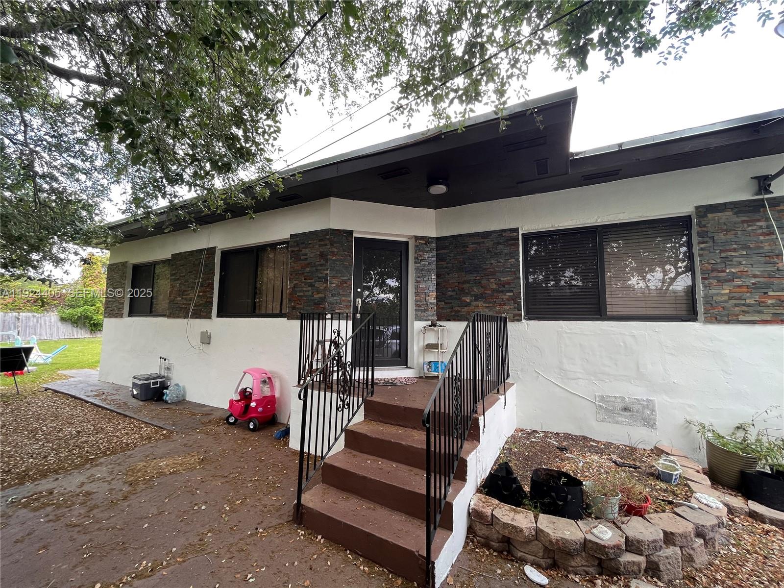 55 Northwest 44th Street Miami, FL 33127 - Photo 18 of 22 a view of a patio with a table and chairs potted plants and a large tree