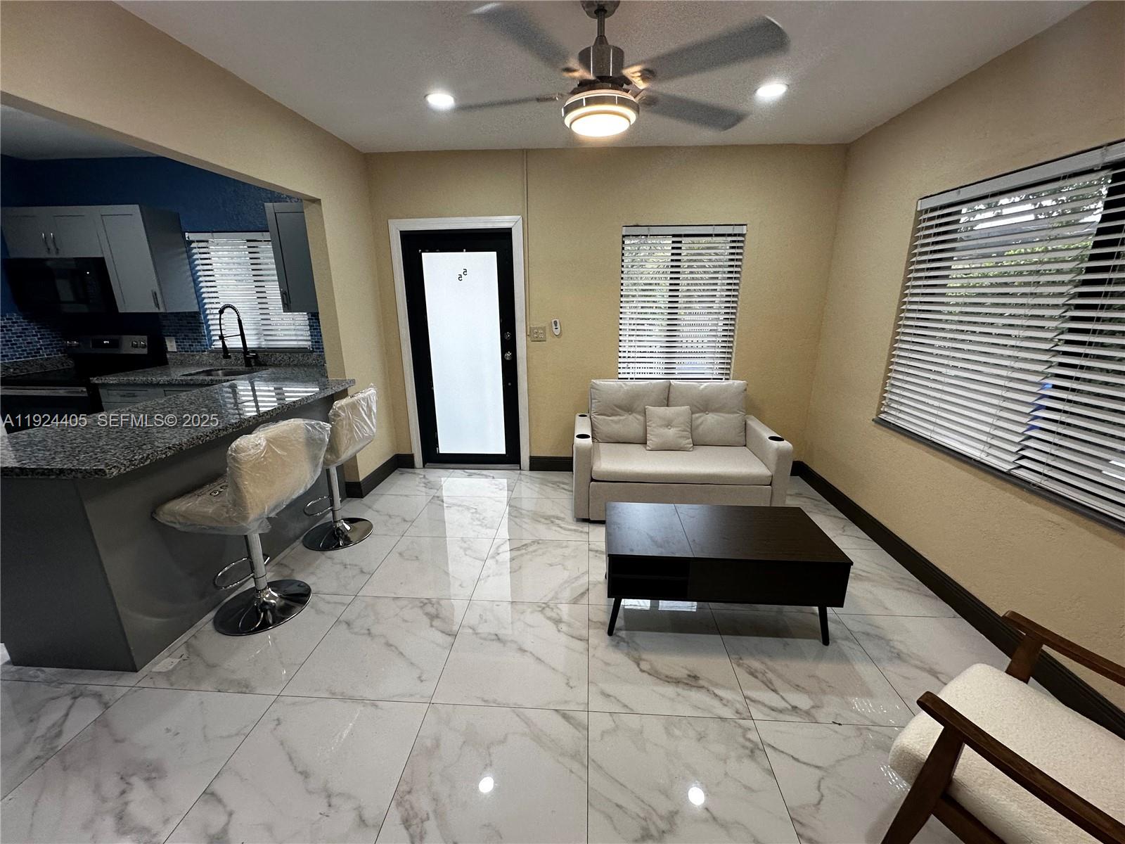 55 Northwest 44th Street Miami, FL 33127 - Photo 4 of 22 a living room with furniture and a large window