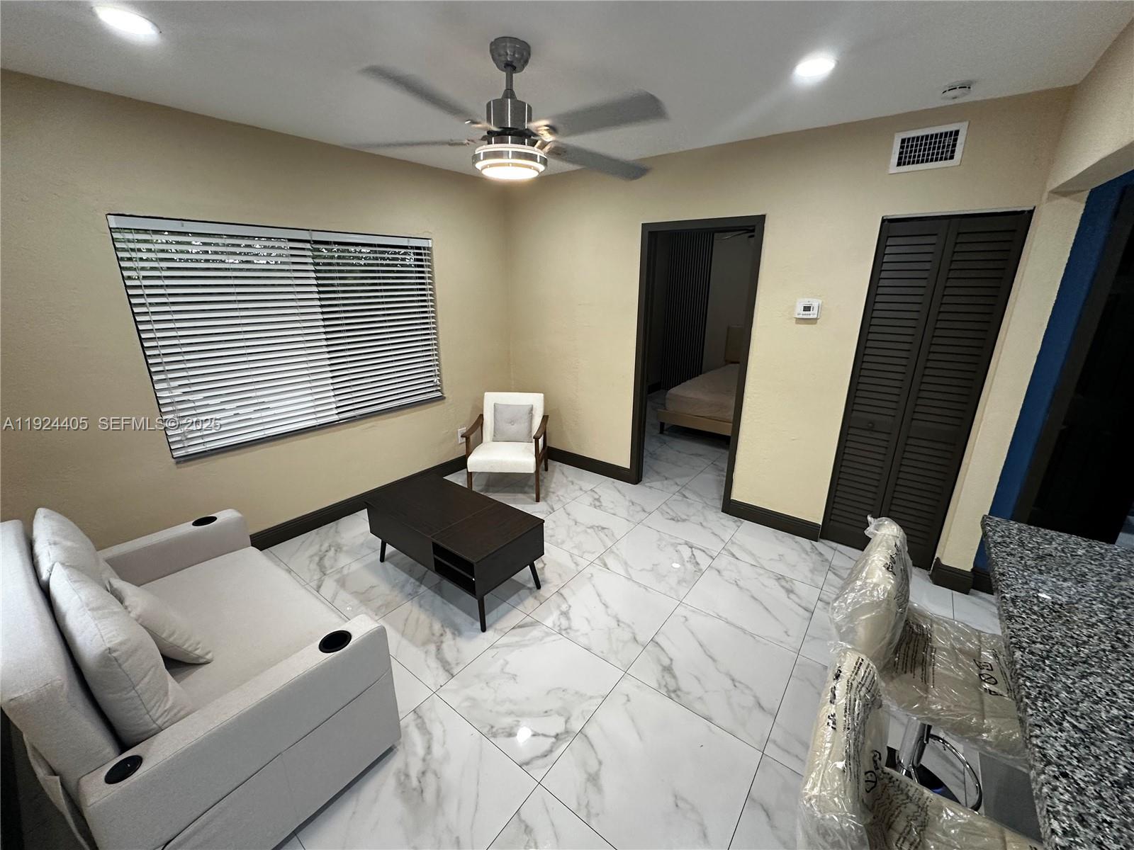 55 Northwest 44th Street Miami, FL 33127 - Photo 6 of 22 a living room with furniture and a flat screen tv