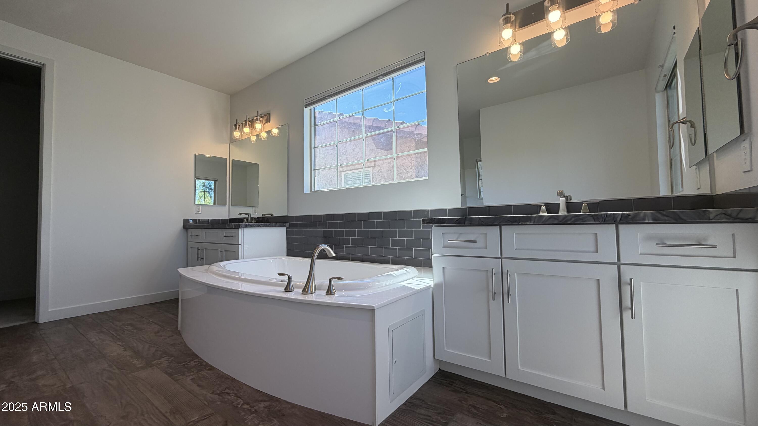 4536 East Walter Way Phoenix, AZ 85050 - Photo 24 of 50 a white bath tub sitting next to a bathroom sink