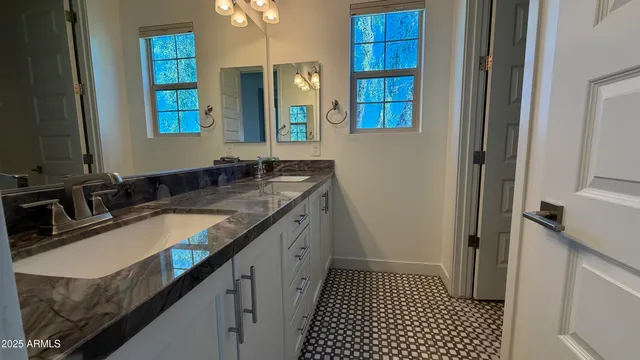 a bathroom with a granite countertop sink and a mirror