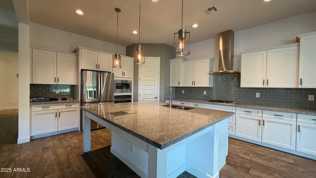 a kitchen with a center island appliances and cabinets