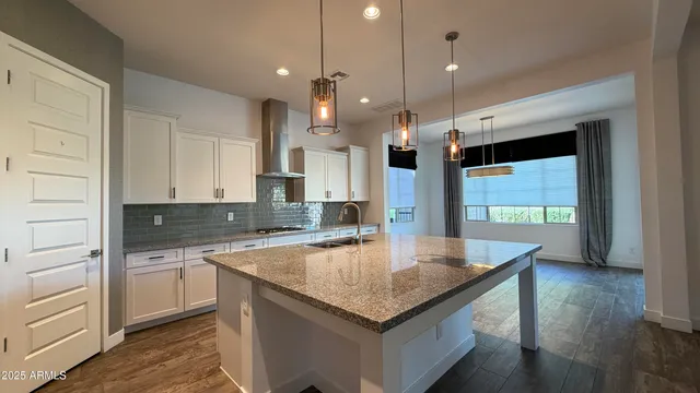 a kitchen with stainless steel appliances granite countertop a sink a stove and a refrigerator