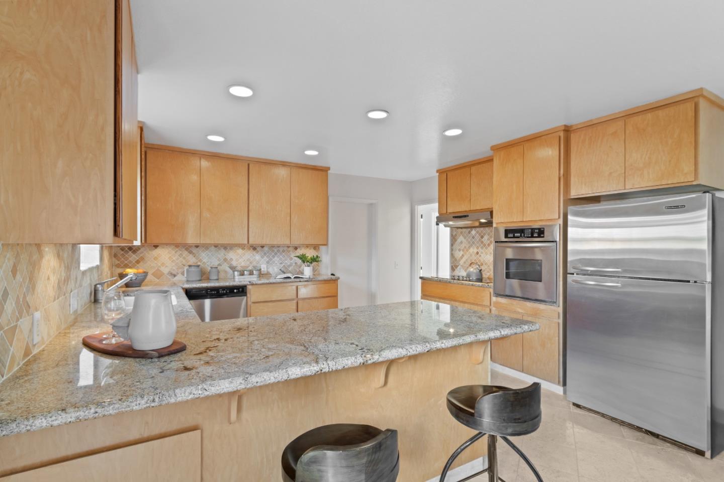 4770 Opal Street Capitola, CA 95010 - Photo 15 of 48 a kitchen with stainless steel appliances granite countertop a sink a stove and a refrigerator with wooden floor