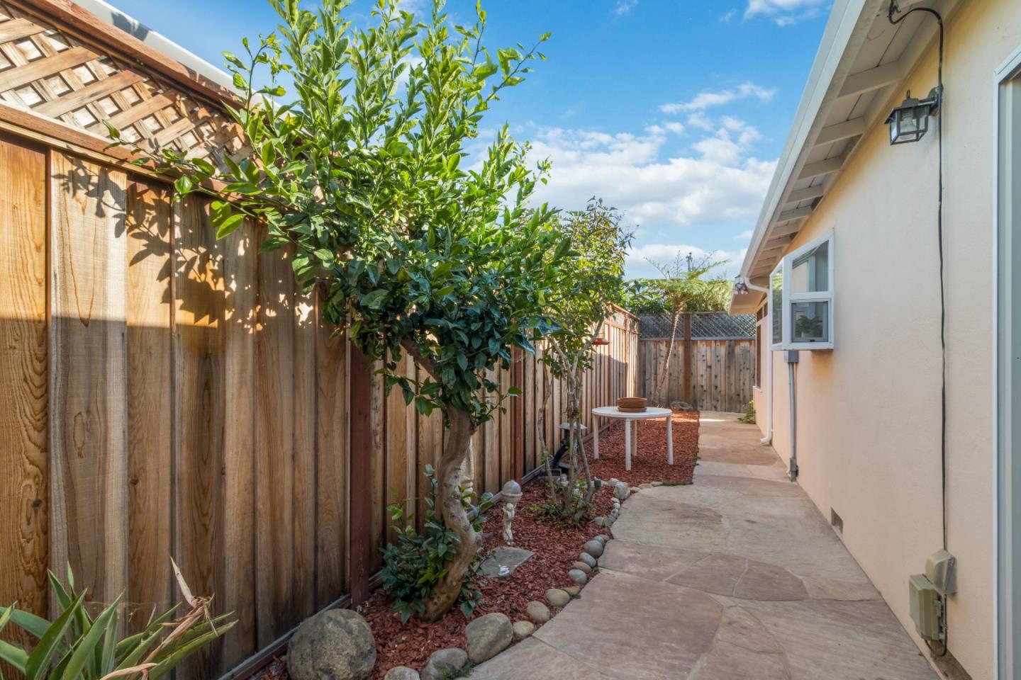 4770 Opal Street Capitola, CA 95010 - Photo 32 of 48 a backyard of a house with chairs plants and wooden fence
