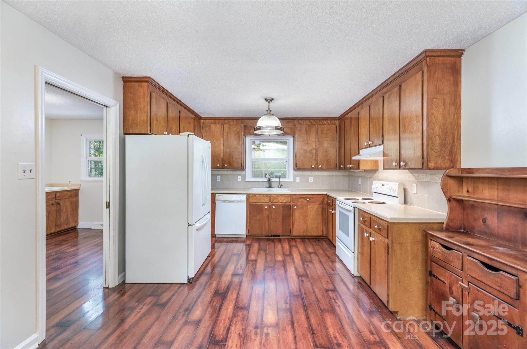 211 Ridgewood Drive Monroe, NC 28112 - Photo 10 of 31 a kitchen with a refrigerator a stove top oven and wooden floors