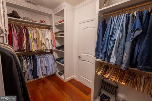 a view of walk in closet with clothes and shoes