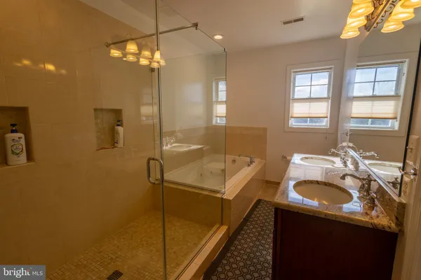 a bathroom with a tub sink vanity and mirror