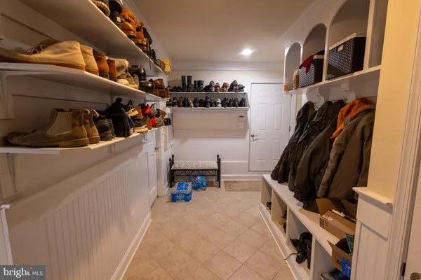 a view of walk in closet with clothes and shoes