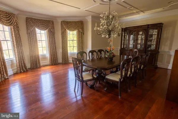 a dining room with furniture a chandelier and wooden floor