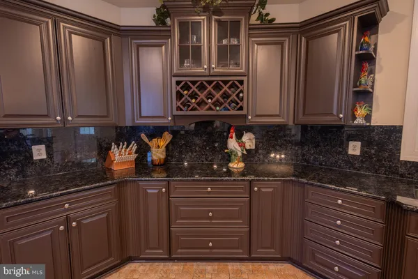 a kitchen with granite countertop a refrigerator and cabinets