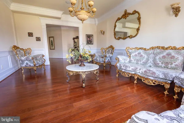 a living room with couches dining table and chairs with wooden floor