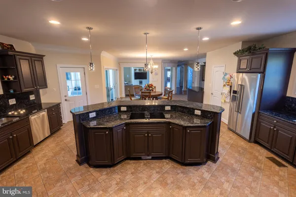 a kitchen with stainless steel appliances granite countertop a sink a stove and a refrigerator