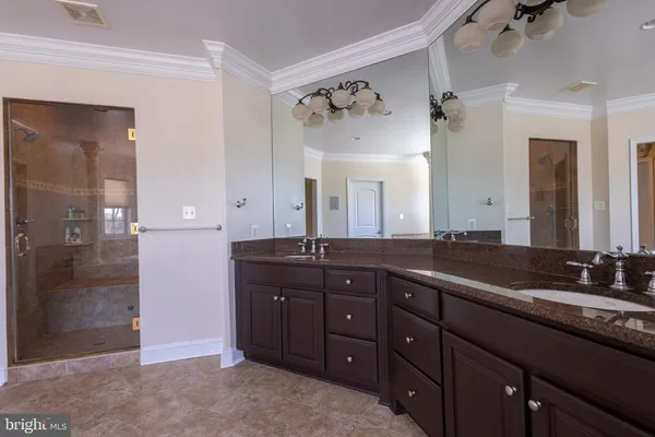 a spacious bathroom with a granite countertop sink a mirror and a shower