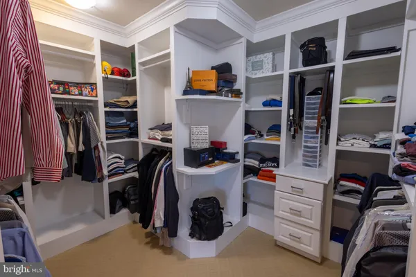 a view of walk in closet with clothes and shoes