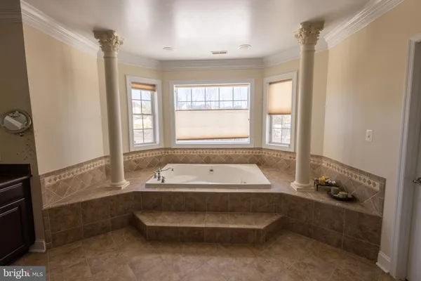 a spacious bathroom with a tub sink and mirror