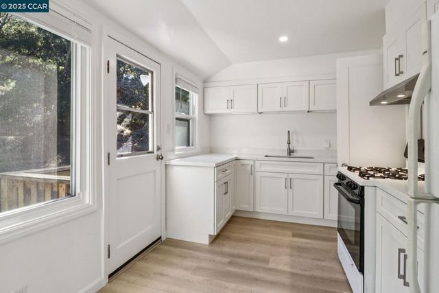 a kitchen with white cabinets and white appliances
