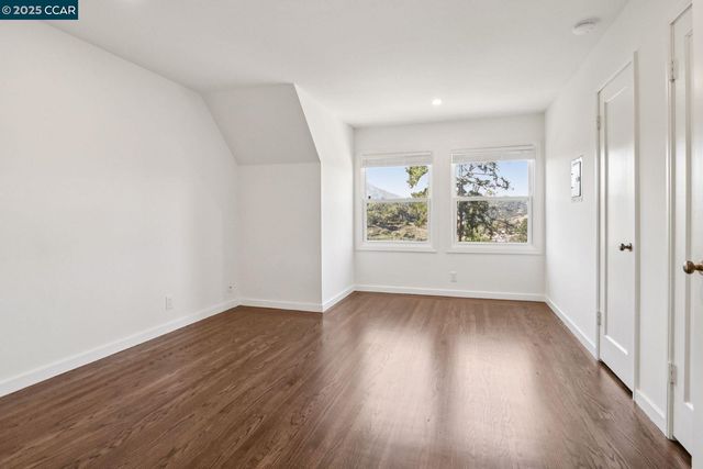 an empty room with wooden floor and window