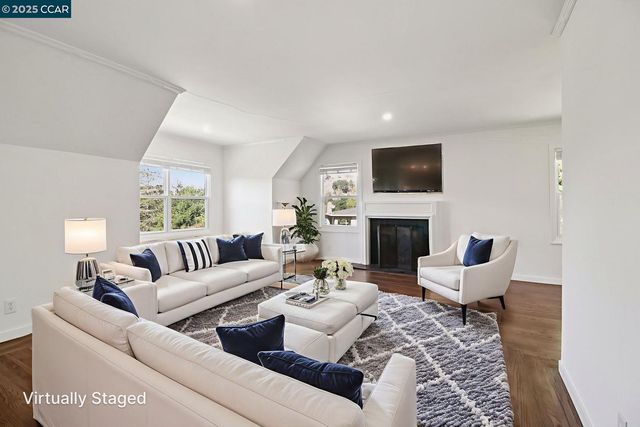 a living room with furniture a fireplace and a flat screen tv