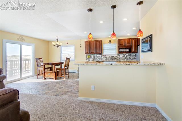 17879 Pinon Park Road Peyton, CO 80831 - Photo 7 of 26 Main level sliding door leads you out side of home to wrap around deck. Granite counter bar!
