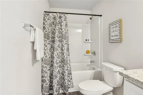 a white toilet sitting next to a bath tub