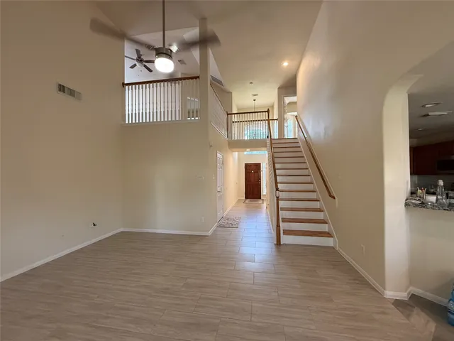 a view of a livingroom with wooden floor and stairs