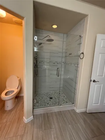 a bathroom with a toilet and a shower