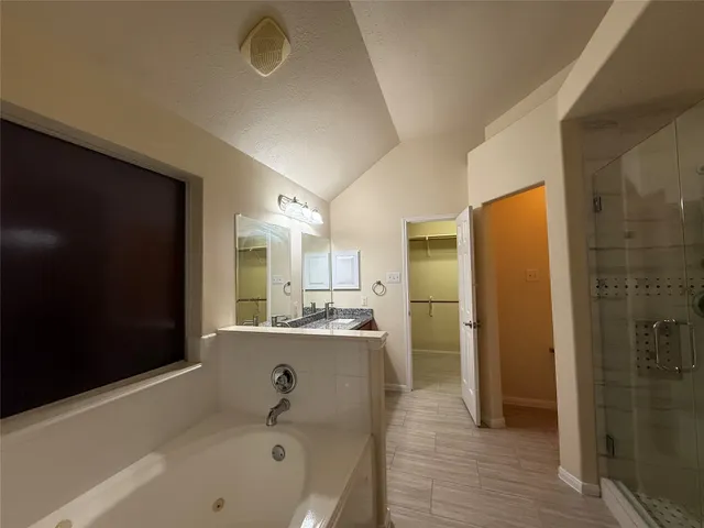 a bathroom with a tub sink shower and mirror