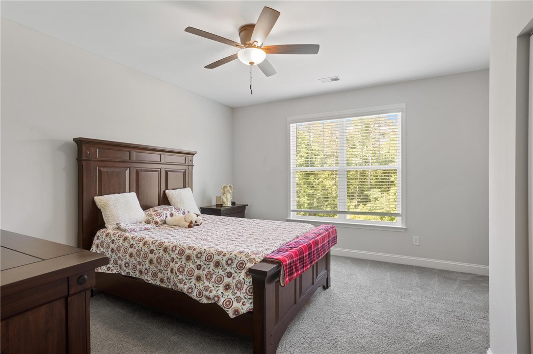 125 Estateside Drive Anderson, SC 29621 - Photo 22 of 37 A tranquil bedroom features a ceiling fan, plush carpeting, and a large window inviting natural light.