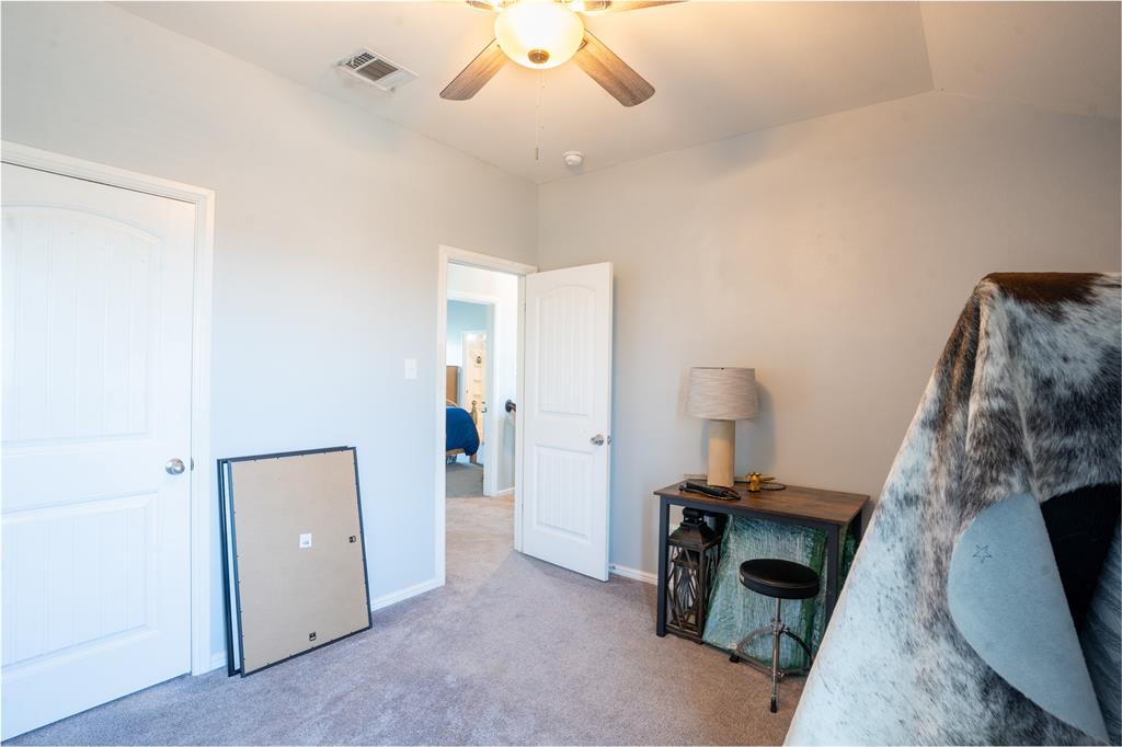 753 Rutherford Drive Crowley, TX 76036 - Photo 23 of 26 Neutral-toned room featuring a ceiling fan with integrated lighting, two paneled interior doors, and plush carpet flooring