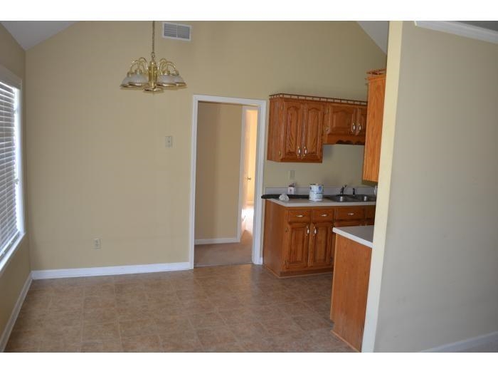 3078 Meade Lake Road Atoka, TN 38004 - Photo 8 of 8 Kitchen featuring wood finish cabinetry, light countertops, suspended lighting, and vaulted ceiling