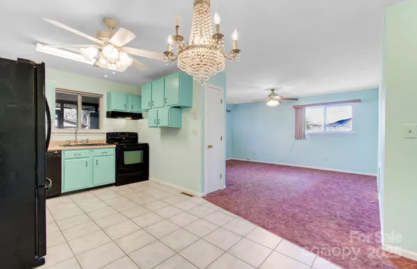 a kitchen that has a lot of white cabinets and stainless steel appliances