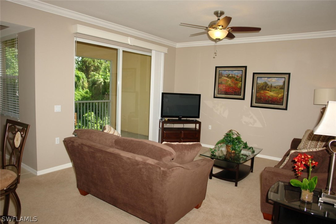8251 Pathfinder Loop, Unit 624 Fort Myers, FL 33919 - Photo 4 of 15 a living room with furniture a flat screen tv and a window