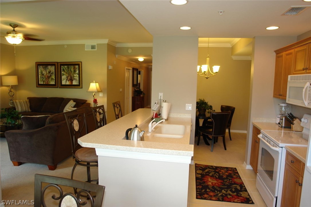 8251 Pathfinder Loop, Unit 624 Fort Myers, FL 33919 - Photo 6 of 15 a living room with furniture a dining table and a flat screen tv