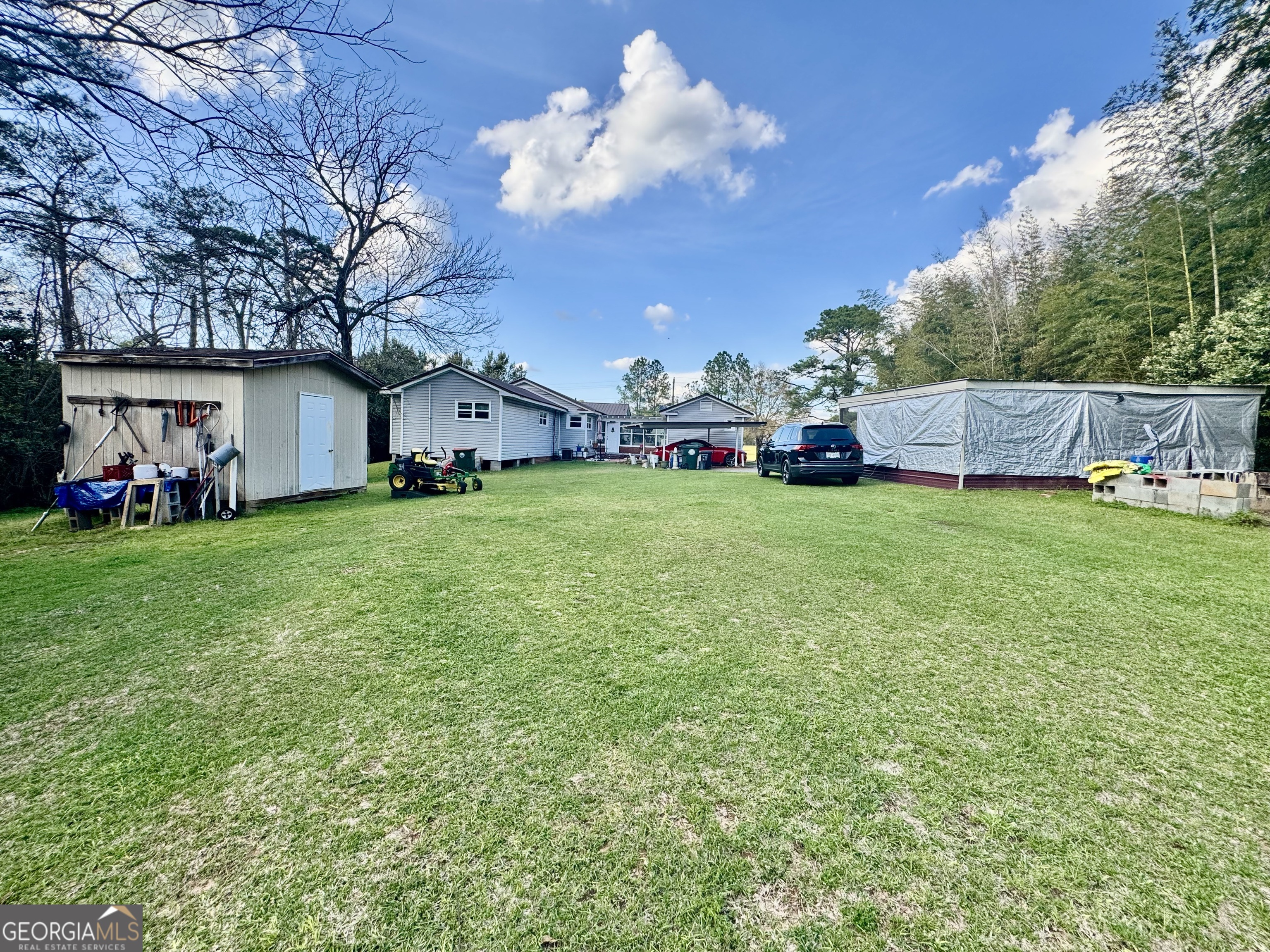 914 Adderton Street Americus, GA 31719 - Photo 12 of 54 a view of a house with a big yard and large trees