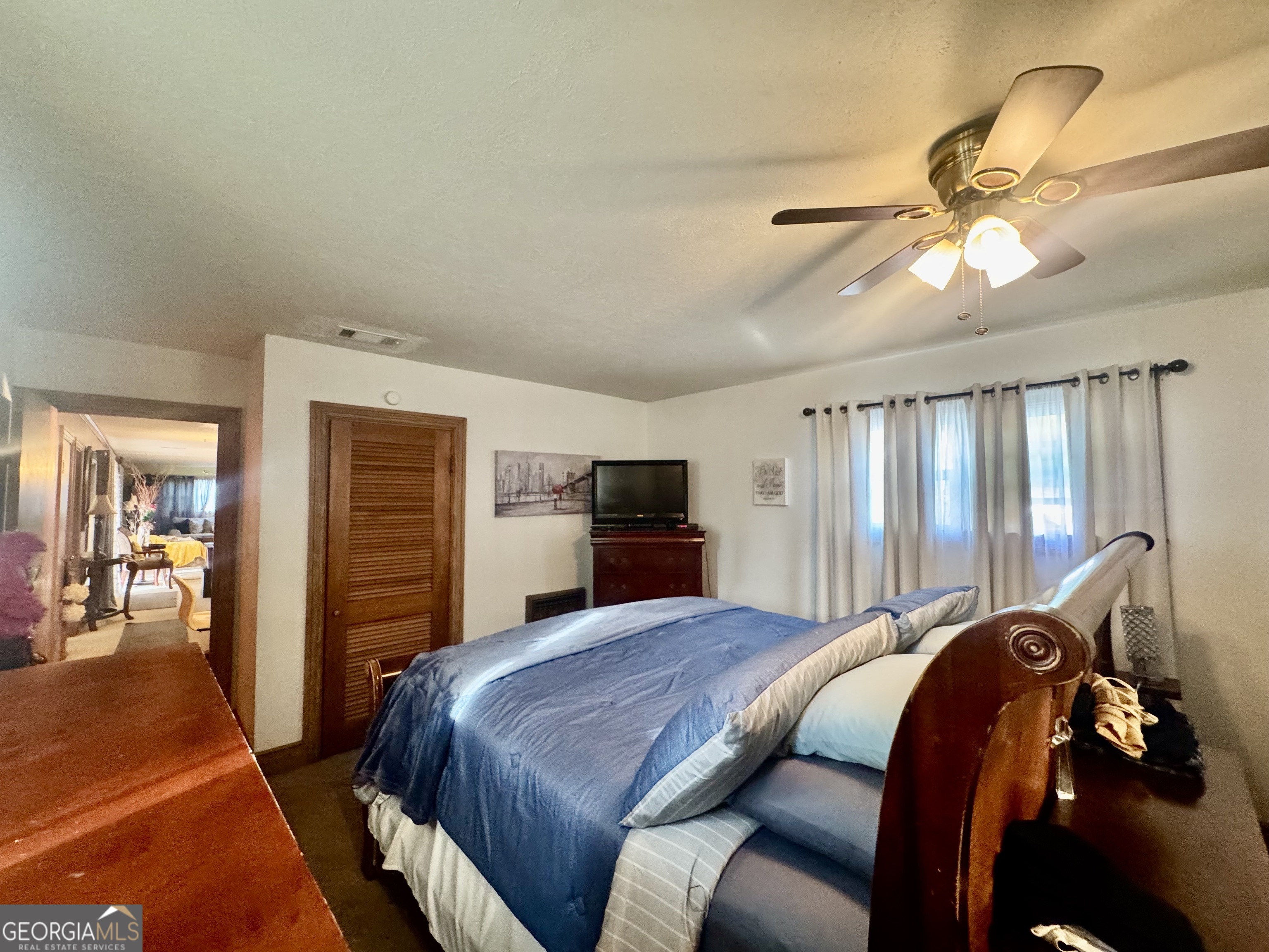 914 Adderton Street Americus, GA 31719 - Photo 28 of 54 a bedroom with a bed and a chandelier
